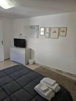 a bedroom with a bed and a tv on a wall at Mak house in Palermo