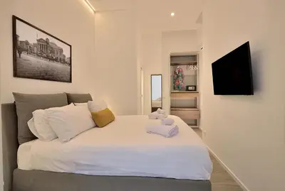 a bedroom with a white bed with a teddy bear on it at Palazzo Gregorietti Boutique Apartments in Palermo