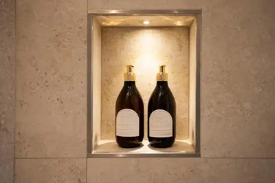 two bottles of wine sitting on a shelf in a bathroom at Dimora Blanca in Bagheria