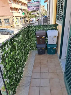 a group of trash cans on a sidewalk next to a building at House victor in Palermo