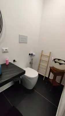 a bathroom with a white toilet and a table at utveggio view apartment in Palermo