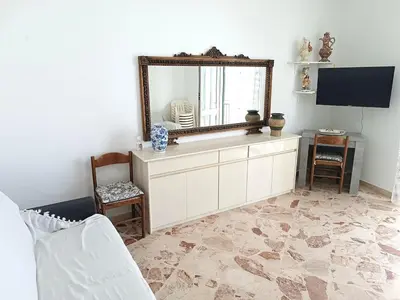 a living room with a mirror and a white dresser at Casa di Laura - Aspra vista mare in Bagheria