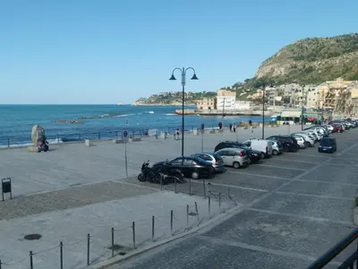 a row of cars parked in a parking lot next to the beach at Casa di Laura - Aspra vista mare in Bagheria