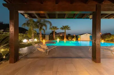 a bedroom with a white bed and a white cabinet at Villa Oxidiana with pool and garden in Campofelice di Roccella