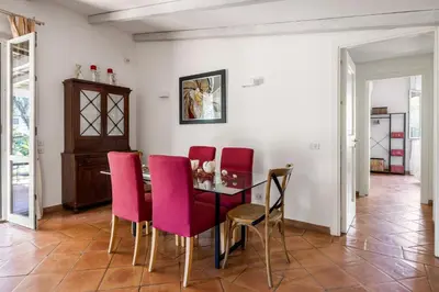 a dining room with a table and pink chairs at Solemar Sicilia - Villa Mondello in Palermo