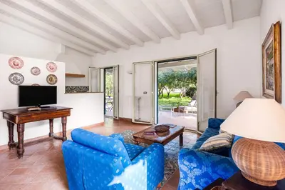a living room with blue chairs and a table at Solemar Sicilia - Villa Mondello in Palermo