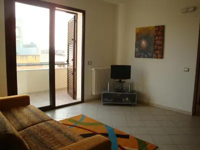a living room with a couch and a television at Appartamenti Campo in Trappeto