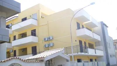 a yellow and white building with balconies at Appartamenti Campo in Trappeto