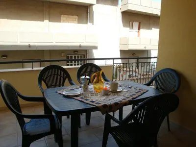 a blue table and chairs with a table and drinks at Appartamenti Campo in Trappeto