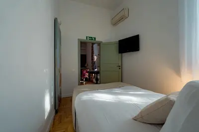a bedroom with two beds and a television on the wall at La Casena del Principe in Palermo