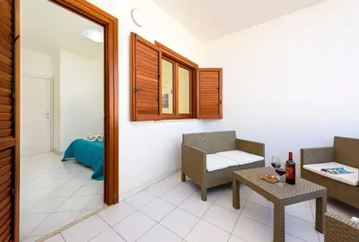 a room with two chairs and a table and a mirror at Bilocale Piano Terra a 400 mt dal mare in San Vito lo Capo