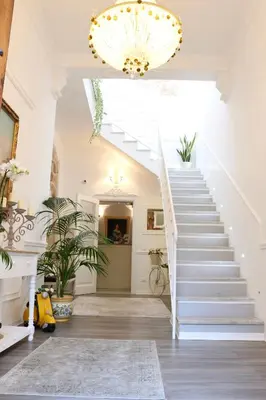a white staircase in a home with a chandelier at TAM Vacanze B&B in Cinisi