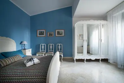 a blue bedroom with a bed and blue walls at Gioia Guesthouse in Alcamo