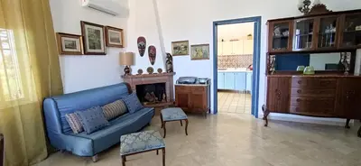 a living room with a blue couch and a fireplace at Gioia Guesthouse in Alcamo