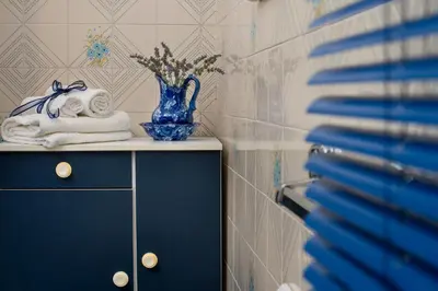 a blue vase sitting on top of a cabinet with towels at Gioia Guesthouse in Alcamo