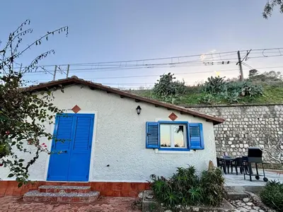 a house with a blue door and a window at Casa Sulla Spiaggia Villa Eléftheria in Altavilla Milicia