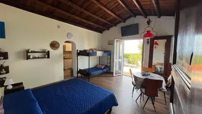a bedroom with a blue bed and a table at Casa Sulla Spiaggia Villa Eléftheria in Altavilla Milicia