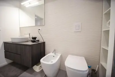 a white bathroom with a toilet and a sink at Casa Pisani 274 in Palermo