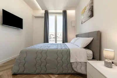 a bedroom with a large bed and a window at GuestHost - Hamuri Holiday House - Heart of Palermo in Palermo