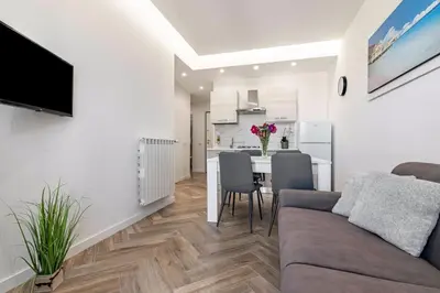 a living room and kitchen with a couch and a table at GuestHost - Hamuri Holiday House - Heart of Palermo in Palermo