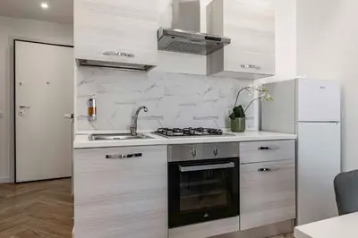 a kitchen with a stove and a sink and a refrigerator at GuestHost - Hamuri Holiday House - Heart of Palermo in Palermo