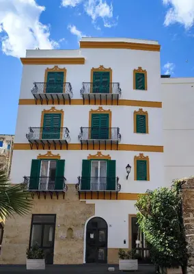 a building with green shutters and balconies at Brunaccini Apartment in Palermo