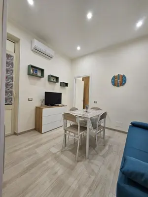 a living room with a table and a blue couch at Casa Amato appartamento alla zisa in Palermo