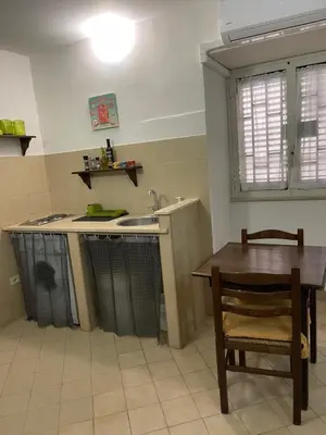 a kitchen with a table and a sink and a table and a chair at Norman City House in Palermo