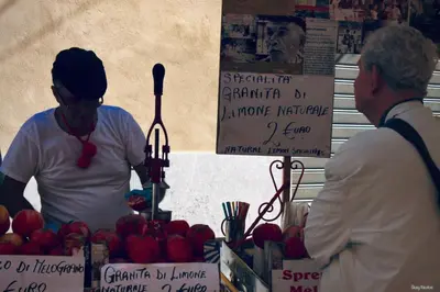 two people standing in front of a fruit stand with apples at UNA Room in Palermo