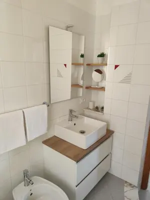 a white bathroom with a sink and a toilet at Villa Marina di Calatubo in Alcamo