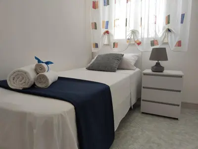 a bedroom with two beds and a table with a lamp at Villa Marina di Calatubo in Alcamo