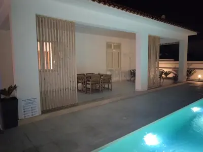 a house with a swimming pool and a dining room at Villa Marina di Calatubo in Alcamo