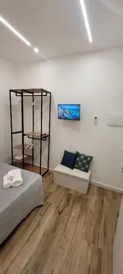 a white room with a bed and a shelf at Idea di Mare in Capaci