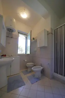 a bathroom with a sink and a toilet and a window at Villa Globo Mondello in Palermo
