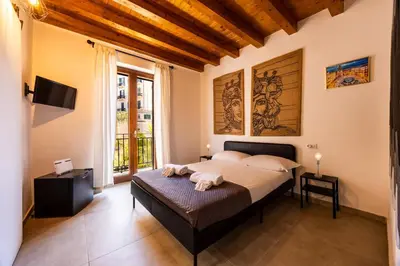 a bedroom with a bed and a large window at Lampionelli 12 Apartment in Palermo