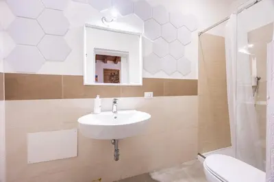 a bathroom with a sink and a toilet and a mirror at Lampionelli 12 Apartment in Palermo