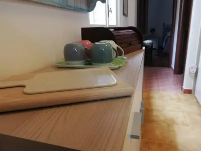 a counter with three coffee mugs on a plate at Bellammari Holiday House in Palermo