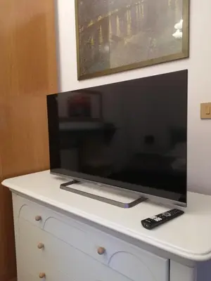 a flat screen tv sitting on top of a white dresser at Bellammari Holiday House in Palermo
