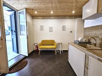 a kitchen with a yellow chair in a room at Duomo Suite - A Step from the Cathedral in Monreale