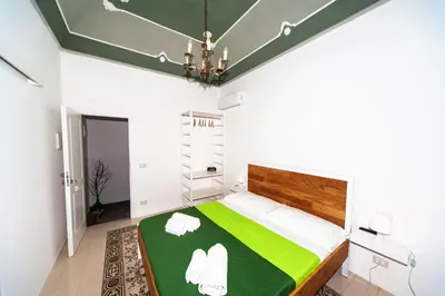 a bedroom with a bed with a green and white comforter at Visitsicilia Donn'Anna in Castellammare del Golfo