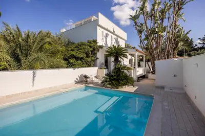 a swimming pool in front of a house at Villa Angela By DomuSicily in Capaci