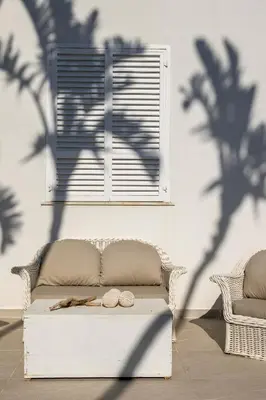a shadow of a palm tree on a wall with a couch at Villa Angela By DomuSicily in Capaci