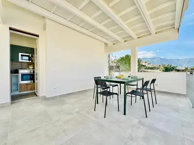 a dining room with a green table and chairs at Sea Life Giulia, spiaggia a 200 mt in Alcamo Marina