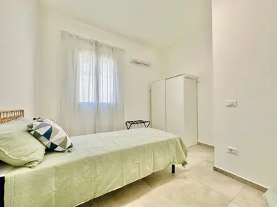a white bedroom with a bed and a window at Sea Life Giulia, spiaggia a 200 mt in Alcamo Marina