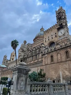 a building with a palm tree in front of it at Mart Rental Apartament in Palermo