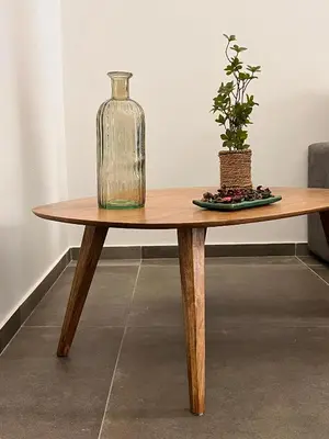 a glass bottle sitting on a wooden table with a plant at N'amuri in Palermo