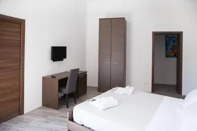 a bedroom with a bed and a desk with a computer at Apartments Porta di Castro in Palermo