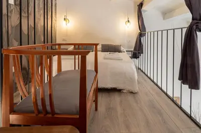 a bedroom with a bed and a chair in it at Il Moro & La Dama in Palermo