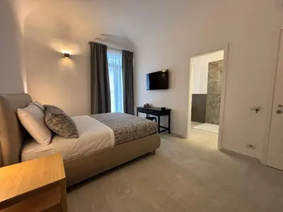 a hotel room with a bed and a television at Historic Palazzo - Apartments & Rooms with Private Bathroom in Palermo