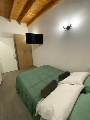 a bedroom with a green and white bed and a flat screen tv at White House Theater Massimo in Palermo